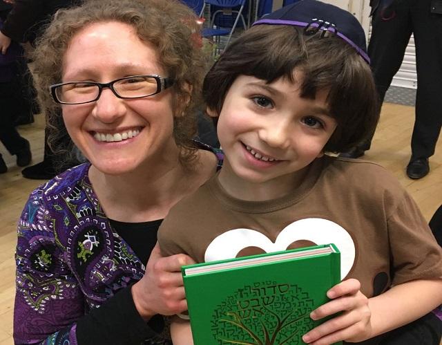 Mum and son holding holding Jewish book 