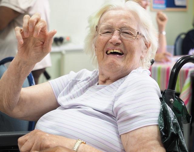 Happy lady in a wheelchair waving