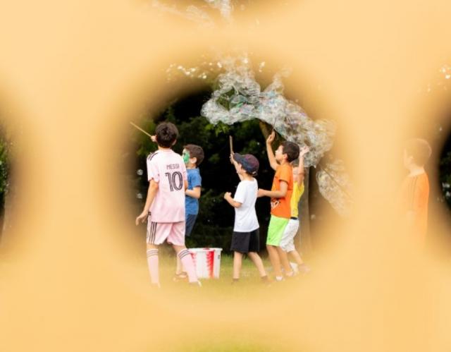 Children trying to catch bubbles