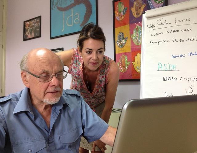 Man sitting at laptop with lady looking over his shoulder 