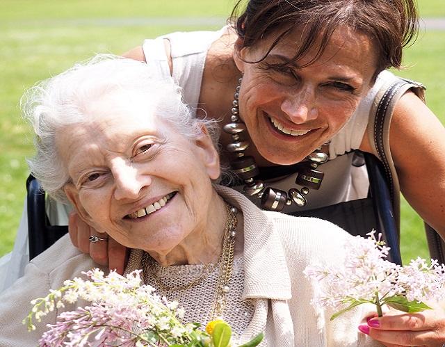 Sue and Marie in the park holding flowers