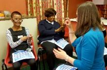 Small group of delegates learning to fingerspell Small group of people learning to fingerspell